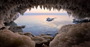 A cave on the Jordanian shore of the Dead Sea near Zara spring, where splashing waves have left a thick layer of salt crystals and stalactites.